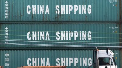 Грузовик проезжает мимо контейнеров ChinaShipping в порту Лос-Анджелеса в Лонг-Бич, Калифорния, 1 сентября 2019 года. (MarkRalston/AFP viaGettyImages)
