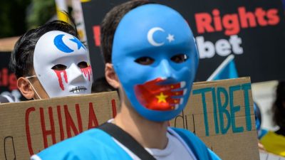 Тибетские и уйгурские активисты в масках во время акции протеста против зимних Олимпийских игр 2022 года в Пекине перед Олимпийским музеем в Лозанне 23 июня 2021 года, когда в акции приняли участие около 200 человек. Фото: PhotobyFabriceCOFFRINI / AFP
