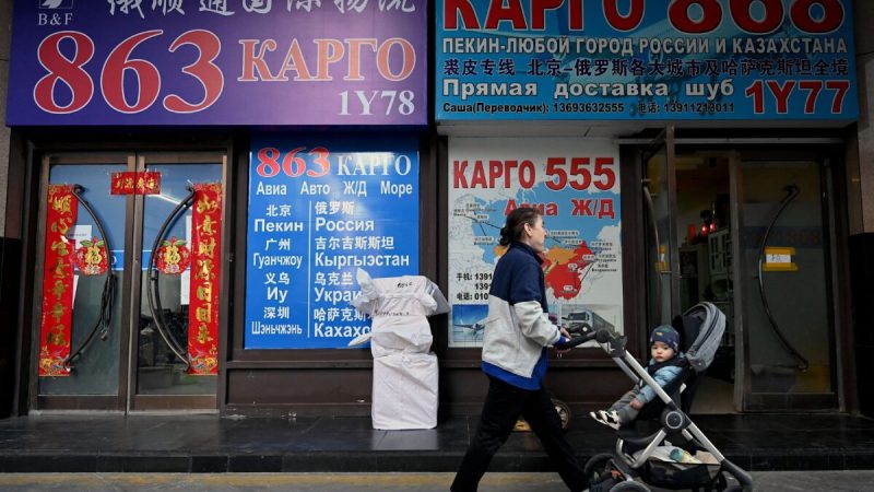 Люди проходят мимо витрин магазинов с вывесками на кириллице в торговом центре, известном как Российский рынок, в Пекине 3 марта 2022 года. (NoelCelis/AFP viaGettyImages) 