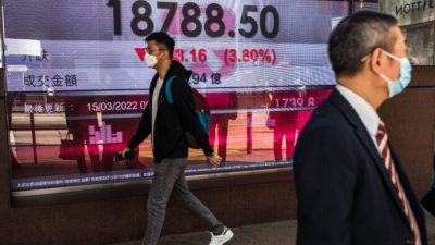 Мужчина проходит мимо дисплея с индексом Hang Seng в Гонконге, 15 марта 2022 года. Фото: (Dale de la Rey/AFP via Getty Images
