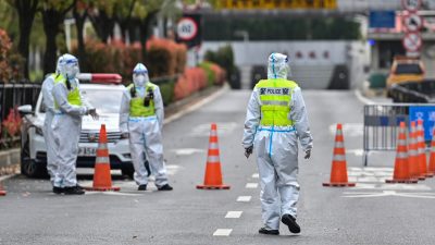 Полицейские в защитном снаряжении контролируют доступ в туннель в направлении района Пудун в Шанхае 28 марта 2022 года. (HECTOR RETAMAL/AFP via Getty Images) 