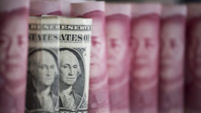 Китайские банкноты в 100 юаней и один доллар США в Пекине 6 января 2017 года. (FredDufour/AFP viaGettyImages)