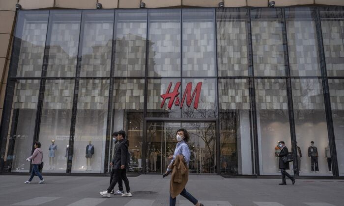 Люди на фоне магазина одежды H&M в торговом районе Пекина, Китай, 30 марта 2021 года. (Kevin Frayer/Getty Images)
