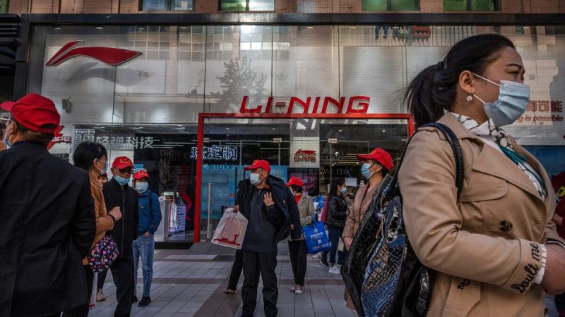 Туристы и покупатели проходят мимо магазина Li-Ning, китайского бренда спортивной одежды, в торговом районе в Пекине 16 апреля 2021 года. (KevinFrayer/GettyImages) 