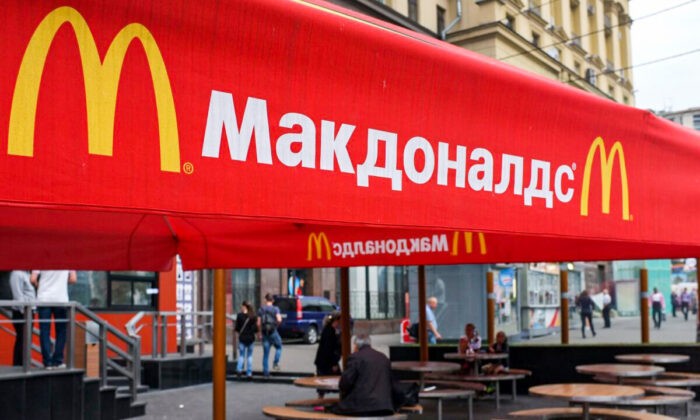 Люди сидят на террасе закрытого ресторана McDonald’s в Москве, 21 августа 2014 года. Фото: AlexanderNemenov/AFPviaGettyImages
