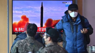 Люди на железнодорожной станции в Сеуле, Южная Корея, 27 февраля 2022 года смотрят по телевизору новости с кадрами испытаний северокорейской ракеты. (Jung Yeon-je/AFP via Getty Images)
