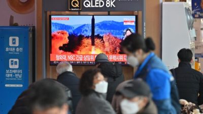 Люди смотрят по телевизору передачу об испытании северокорейской ракеты. Железнодорожная станция в Сеуле, Южная Корея, 27 февраля 2022 года. (JungYeon-je/AFP viaGettyImages)
