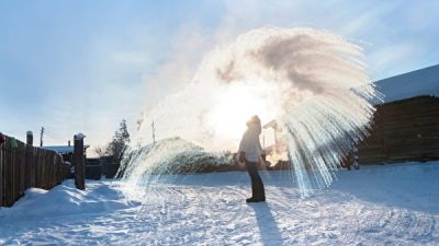 Республика Саха — самое холодное место из всех обитаемых территорий в мире. На снимке местная жительница разбрызгивает в воздухе горячую воду — и вода быстро замерзает. Выглядит красиво, подобно фейерверку (изображение: Shutterstock)