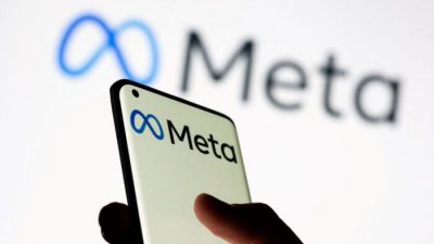 Женщина держит смартфон с логотипом Meta** перед изображением нового ребрендингового логотипа Facebook Meta** на этой иллюстрации, сделанной 28 октября 2021 года. (Dado Ruvic/Illustration/Reuters)