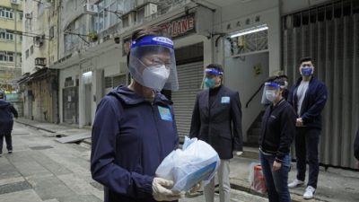 Глава администрации Гонконга Кэрри Лам (слева) держит пакет материалов по профилактике COVID-19, которые будут доставлены людям во время противоэпидемического мероприятия в Гонконге, 2 апреля 2022 года. Фото: Kin Cheung/AP Photo
