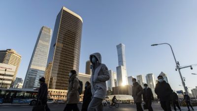 Пешеходы переходят дорогу перед зданиями в центральном деловом районе Пекина, Китай, 23 ноября 2021 года. (Qilai Shen/Bloomberg via Getty Images)
