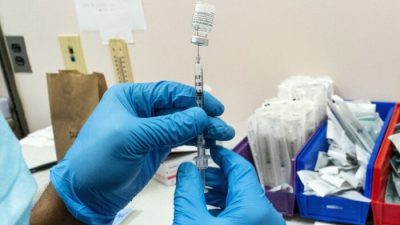 Фармацевт готовит дозу вакцины в пункте вакцинации COVID-19 в Нью-Йорке 24 февраля 2021 года. (AP Photo/Mary Altaffer)