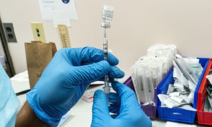 Фармацевт готовит дозу вакцины в пункте вакцинации COVID-19 в Нью-Йорке 24 февраля 2021 года. (AP Photo/Mary Altaffer)