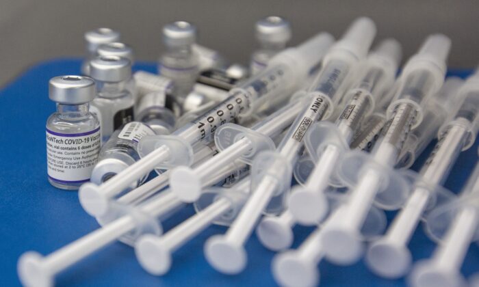 Шприцы и флаконы с вакциной COVID-19 компании Pfizer-BioNTech на рабочей поверхности во время работы клиники в колледже Святого Лаврентия в Кингстоне, Онталия, 18 декабря 2021 года. (The Canadian Press/Lars Hagberg)
