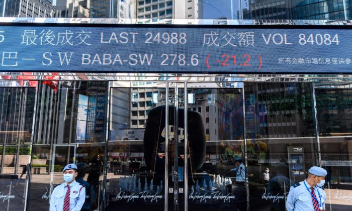 Строка с активностью акций Alibaba Group Holding Ltd (BABA-SW) над охранниками у башен Exchange Square в Гонконге, 4 ноября 2020 г. (Anthony Wallace/AFP via Getty Images)

