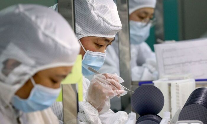 Сотрудники производят микросхемы на заводе Jiejie Semiconductor Company в Наньтуне, провинция Цзянсу на востоке Китая, 17 марта 2021 года. (STR/AFP via Getty Images)