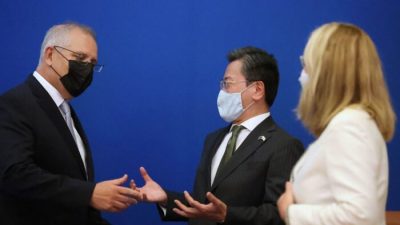 Премьер-министр Австралии Скотт Моррисон (слева) разговаривает с послом Японии в Австралии Синго Ямагами (в центре) после виртуального саммита с премьер-министром Японии Кисида Фумио в Канберре 6 января 2022 года, который ознаменовал открытие новой главы сотрудничества в области обороны и безопасности между двумя странами с подписанием соглашения о взаимном доступе. (AFP via Getty Images)
