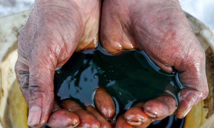 Работник держит образец сырой нефти на Ярактинском месторождении, принадлежащем Иркутской нефтяной компании, в Иркутской области России 11 марта 2019 года. (Vasily Fedosenko/Reuters)