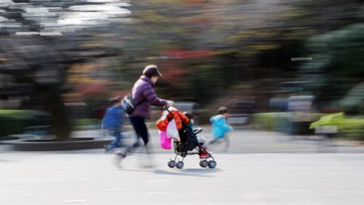 Файловое изображение женщины с коляской, гуляющей с детьми в парке в Токио. (Yoshikazu Tsuno/AFP via Getty Images)