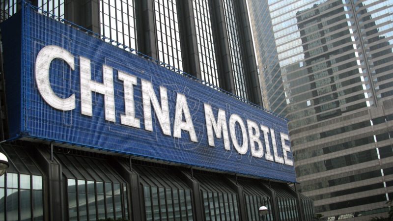 Большой рекламный щит China Mobile на стене здания в Гонконге, 14 марта 2010 г. (Daniel Sorabji/AFP via Getty Images)   