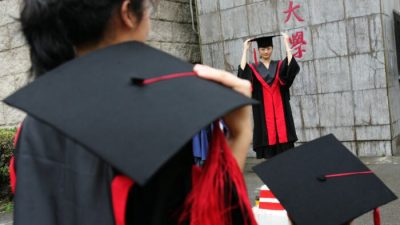 Выпускники во время церемонии вручения дипломов в Университете Жэньминь в Пекине 29 июня 2006 года. Китайский инвестор Чжан Лэй пожертвовал миллионы университету Жэньминь на создание исследовательского института искусственного интеллекта. (China Photos/Getty Images)