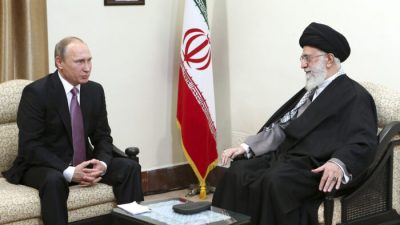 Верховный лидер аятолла Али Хаменеи (справа) и президент России Владимир Путин на встрече в Тегеране, Иран. На стене висит портрет покойного основателя иранской революции Аятоллы Хомейни. (OfficeoftheIranianSupremeLeadervia AP)