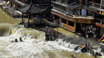Паводковые воды проносятся через древний город Фэнхуан в центральной китайской провинции Хунань, 4 июня 2022 года. (AP Photo)