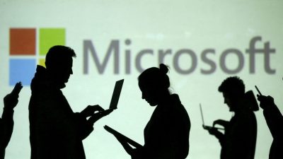 Силуэты пользователей ноутбуков и мобильных устройств рядом с проекцией логотипа Microsoft 28 марта 2018 г. Фото: Dado Ruvic/Illustration/Reuters