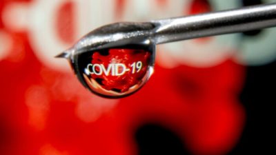 Слово COVID-19 отражено в капле на игле шприца на иллюстрации, сделанной 9 ноября 2020 года. (Dado Ruvic/Illustration/Reuters)