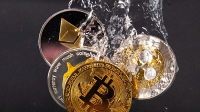 Сувенирные жетоны, представляющие криптовалютные сети Bitcoin, Ethereum, Dogecoin и Ripple, погружаются в воду на этой иллюстрации 17 мая 2022 года. (Dado Ruvic/Illustration/Reuters)