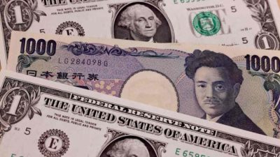 Японские банкноты номиналом 1 000 иен и 1 доллар США в Токио 13 апреля 2022 года. (Behrouz Mehri/AFP via Getty Images)