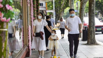 Люди идут по улице в Шанхае 2 июня 2022 года. (Hu Chengwei/Getty Images)