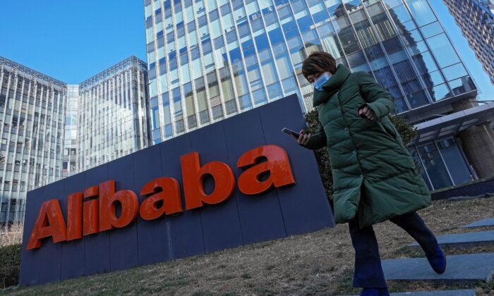 Женщина на фоне офиса китайской фирмы электронной коммерции Alibaba в Пекине, Китай, 13 декабря 2021 года. (Andy Wong/AP Photo)
