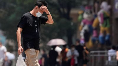 Мужчина на улице во время предупреждения о сильной жаре в Шанхае, 13 июля 2022 г. (Aly Song/Reuters)