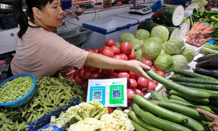 QR-коды Alipay и Wechat для онлайн-платежей на овощном рынке в Наньтуне в провинции Цзянсу. 10 сентября 2018 года. (STR/AFP via Getty Images)