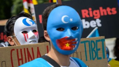 Около 200 уйгурских активистов в масках на акции протеста против зимних Олимпийских игр 2022 года в Пекине 23 июня 2021 года. Фото: Fabrice COFFRINI / AFP

