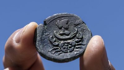 Редкая бронзовая монета возрастом около 1850 лет, обнаруженная у израильского прибрежного города Хайфа, выставлена в офисе Управления древностей Израиля в Иерусалиме, 26 июля 2022 года. (Tsafrir Abayov/AP Photo)