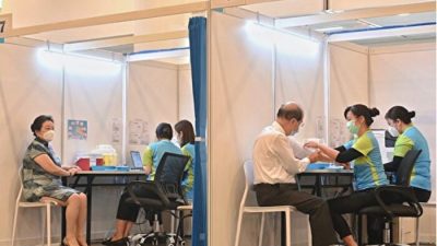 Два местных чиновника прививаются вакциной китайского производства Sinovac от COVID-19. 26 февраля правительство Гонконга начало вакцинацию от COVID-19 для приоритетных групп, включающих людей старше 60 лет. (Song Bilong/The Epoch Times)