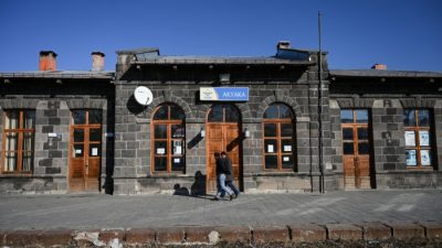 Двое мужчин идут перед железнодорожной станцией Акьяка 9 января 2022 года в районе Акьяка города Карс, восточная Турция, недалеко от турецко-армянской границы. (Ozan Kose/AFP via Getty Images)