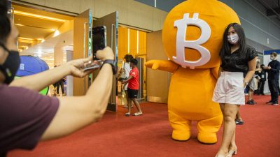 Женщина с биткойн-талисманом на выставке Crypto Expo 2022 в Бангкоке, Таиланд, 14 мая 2022 года. (Lauren DeCicca/Getty Images) 