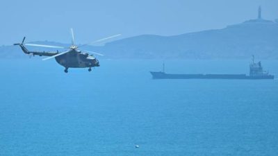 Китайский военный вертолёт пролетает мимо близкого к Тайваню острова Пинтан 4 августа 2022 года. (Фото: HECTOR RETAMAL/AFP via Getty Images)