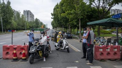 Полицейские проверяют информацию о людях на блокпосте 1 сентября 2022 года из-за ограничений, связанных со вспышкой COVID-19 в Чэнду, юго-западная провинция Сычуань, Китай. (CNS/AFP через Getty Images)