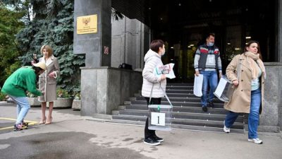 Члены избирательной комиссии с переносными урнами для голосования покидают посольство самопровозглашённой Донецкой Народной Республики в Москве 23 сентября 2022 года. (Photo by ALEXANDER NEMENOV/AFP via Getty Images)