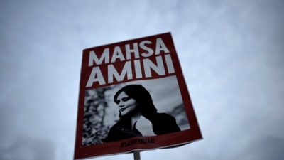 Женщина держит плакат с изображением иранки Махсы Амини на акции протеста в Берлине 28 сентября 2022 года. (Markus Schreiber/AP Photo)