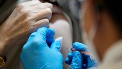 Человек получает вакцину COVID-19 в Токио 31 января 2022 года. (Eugene Hoshiko/Pool/AFP via Getty Images)