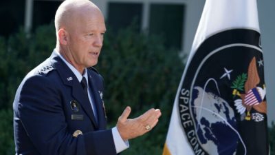 Генерал космического командования ВВС США Джон «Джей» Рэймонд стоит рядом с флагом недавно созданного Космического командования США, шестой национальной вооруженной службы, в Розовом саду в Белом доме 29 августа 2019 года.  (Chip Somodevilla/Getty Images)
