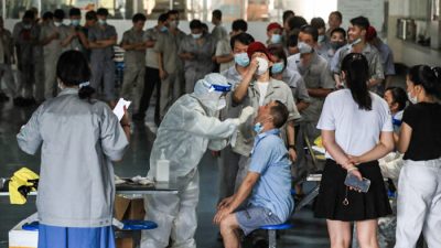 Рабочие завода автомобильных запчастей в Ухане проходят тест на COVID-19, провинция Хубэй в центральном Китае, 4 августа 2021 года. (STR/AFP via Getty Images)