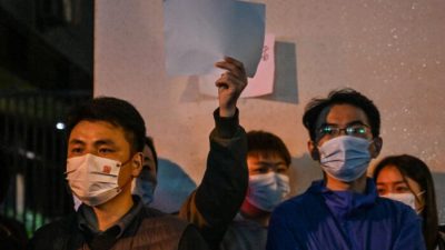 Люди держат чистые листы бумаги в знак протеста в Шанхае 27 ноября 2022 года, где накануне прошли акции протеста против политики «нулевого COVID» Китая после смертельного пожара в Урумчи, столице региона Синьцзян. Фото: Hector Retamal/AFP/Getty Images