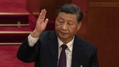 Китайский лидер Си Цзиньпин поднимает руку во время голосования во время заключительного заседания 20-го Национального конгресса коммунистической партии Китая в Доме народных собраний в Пекине 22 октября 2022 года. (Kevin Frayer/Getty Images)
