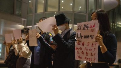 Протестующие держат в руках белые листы, некоторые из которых написаны в память о смертоносном пожаре в Урумчи 24 ноября, во время собрания в Университете Гонконга в Гонконге 29 ноября 2022 года. (AP Photo/Bertha Wang)